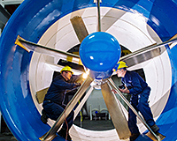 Employees inspect a hydrokinetic turbine